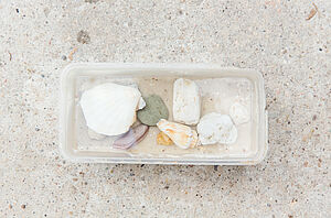 Eine Plastikdose mit Steinen