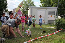Eine Kindergartengruppe lässt eine selbstgebastelte Rakete starten