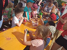 Kinder an einem langen Tisch beschäftigen sich mit Luftballons