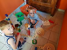 Zwei Jungen spielen mit Murmelbahnen