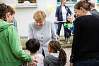 Bundeskanzlerin Angela Merkel wird zum Tag der kleinen Forscher 2016 in Berlin von zwei Kindern begrüßt
