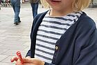 Ein Kind hält zwei ineinandergesteckte Strohhälme in der Hand