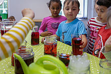 Kinder färben Wasser rot in Gläsern