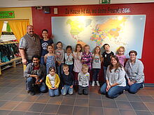 Gruppenbild einer Kitagruppe vor einer Weltkarte