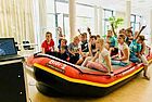 Grundschulkinder sitzen in einem Schlauchboot