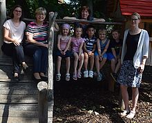 Die niedersächsische Kultusministerin Frauke Heiligenstadt sitzt mit Kindern und Erzieherinnen auf einem hölzernen Klettergerüst